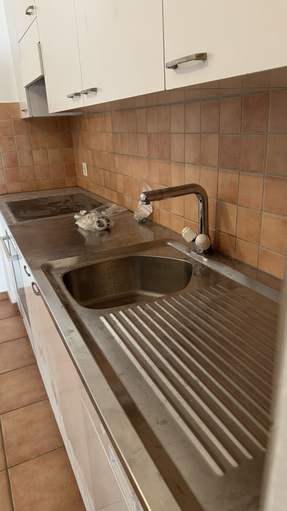 Évier et plan de travail en inox avec traces d'eau et dépôts